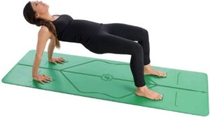 Die rutschfeste LIFORME Yogamatte. Eine junge Frau in schwarzer Sportbekleidung praktiziert Yoga auf der rutschfesten grünen LIFORME Yogamatte